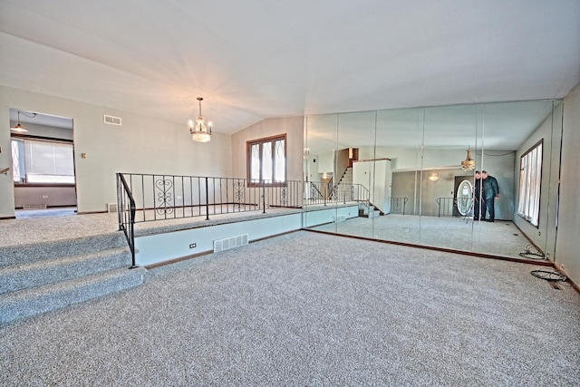 interior space with light carpet, a wealth of natural light, and a chandelier