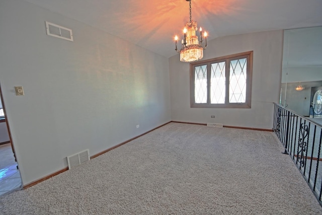 carpeted empty room featuring a chandelier