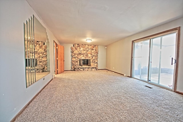 unfurnished living room with a stone fireplace and carpet floors