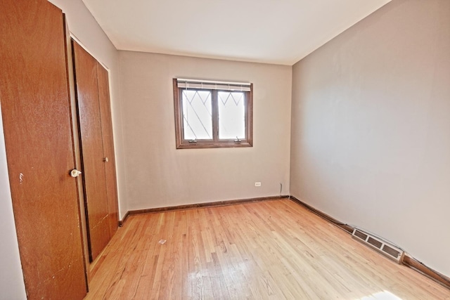 unfurnished bedroom with a closet and light wood-type flooring