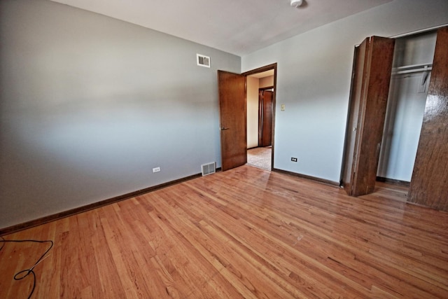 unfurnished bedroom with a closet and light wood-type flooring