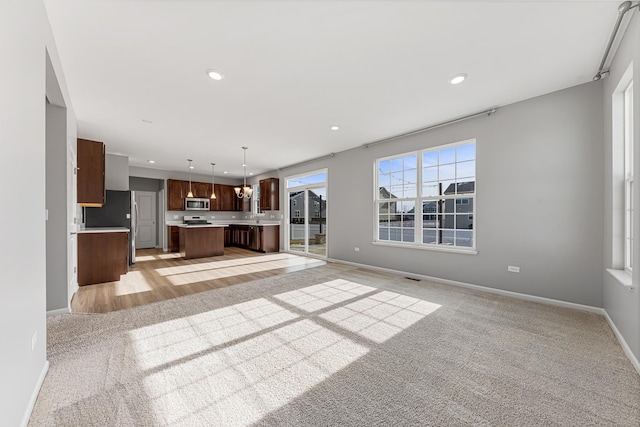 unfurnished living room featuring light colored carpet