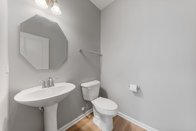 bathroom featuring hardwood / wood-style flooring and toilet