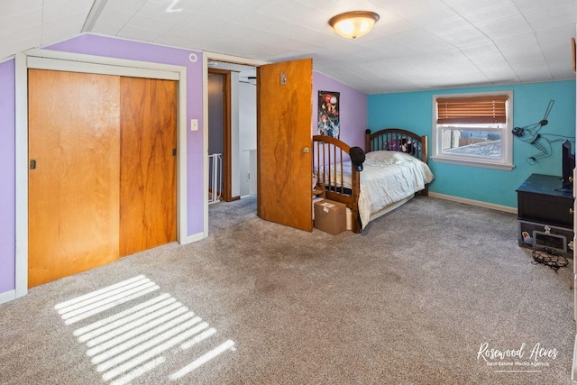 carpeted bedroom with a closet and vaulted ceiling