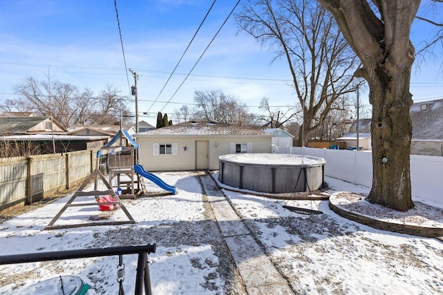 snow covered house featuring a playground