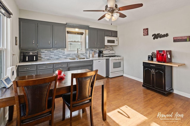 kitchen with sink, gray cabinets, white appliances, and tasteful backsplash