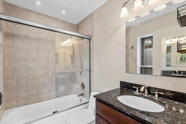 full bathroom with toilet, vanity, and shower / bath combination with glass door