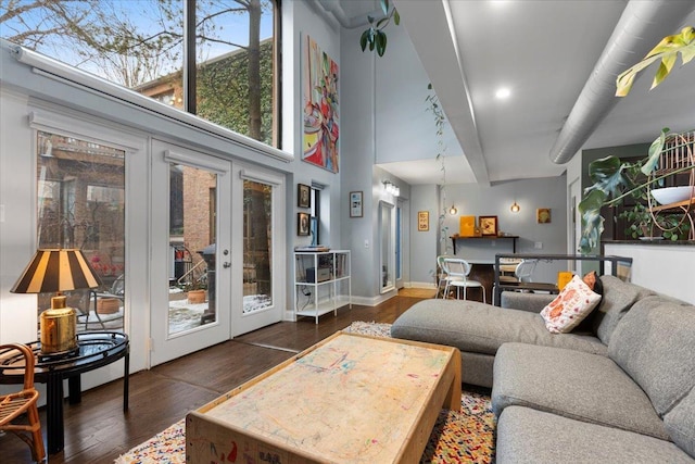 living room with a high ceiling, dark hardwood / wood-style flooring, and french doors