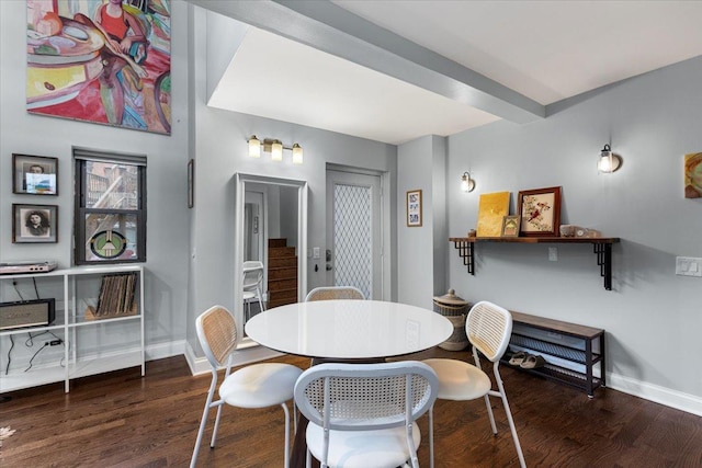 dining space with dark wood-type flooring and beamed ceiling