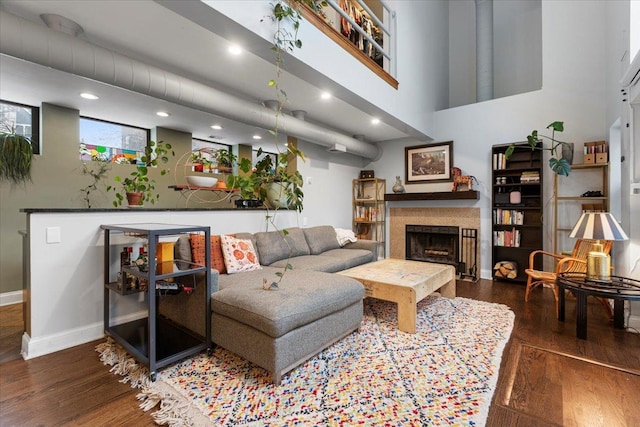 living room featuring dark wood-type flooring and a towering ceiling