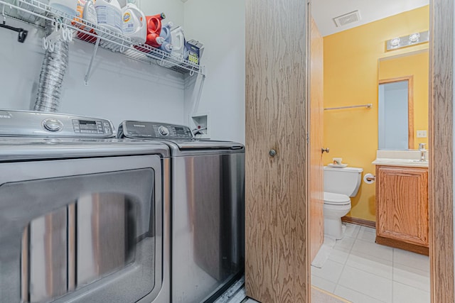 washroom featuring light tile patterned floors, sink, and washer and dryer