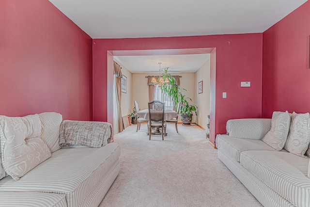 carpeted living room featuring a notable chandelier