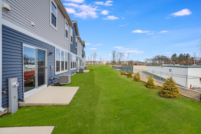 view of yard with a patio area, fence, and central air condition unit