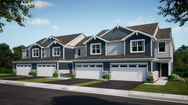 view of front of house featuring a garage, stone siding, and driveway