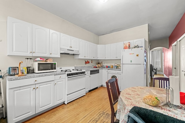 kitchen featuring white appliances, white cabinets, light hardwood / wood-style flooring, and washer / clothes dryer