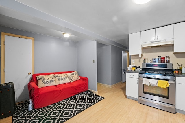 kitchen featuring white cabinets, stainless steel gas range oven, and light hardwood / wood-style flooring