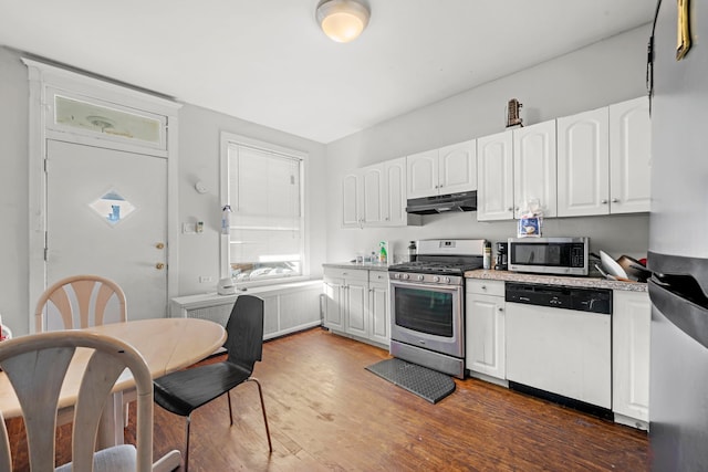 kitchen with white cabinets, appliances with stainless steel finishes, and dark hardwood / wood-style flooring