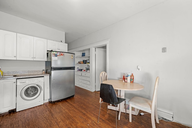 kitchen with dark hardwood / wood-style floors, white cabinets, washer / dryer, and stainless steel refrigerator