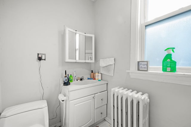 bathroom featuring toilet, vanity, a wealth of natural light, and radiator heating unit