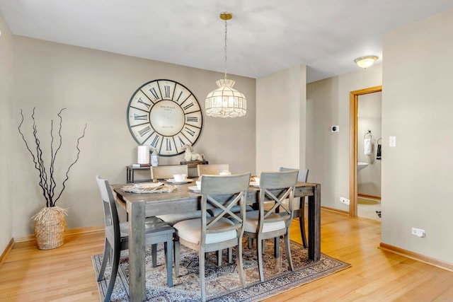 dining area featuring light wood finished floors and baseboards