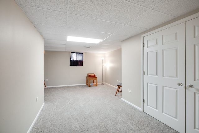 basement featuring carpet floors and a drop ceiling