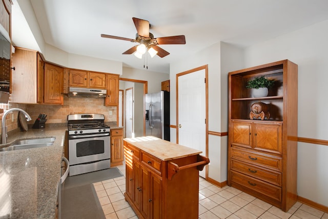 kitchen with sink, light tile patterned floors, decorative backsplash, and appliances with stainless steel finishes