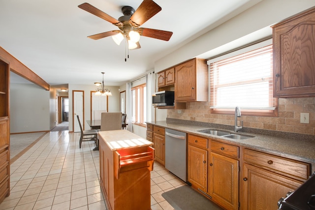 kitchen featuring sink, light tile patterned floors, appliances with stainless steel finishes, pendant lighting, and decorative backsplash