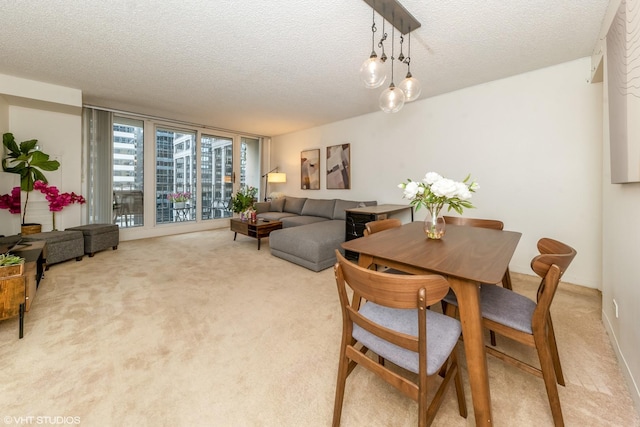 dining room with light colored carpet and a textured ceiling