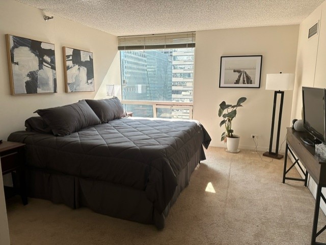 bedroom featuring light carpet, floor to ceiling windows, and a textured ceiling