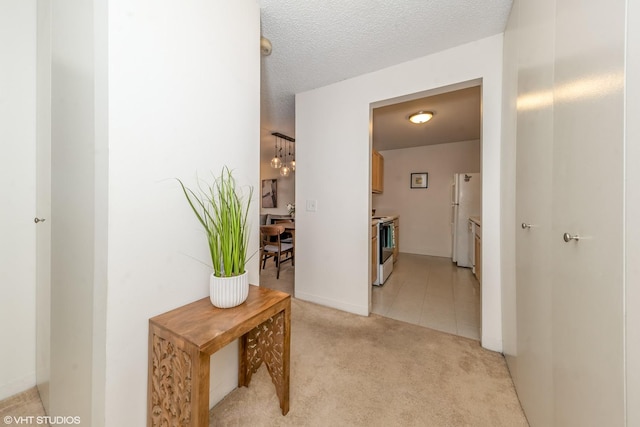 corridor featuring a textured ceiling and light colored carpet