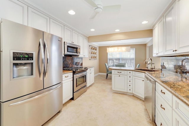 kitchen with sink, white cabinetry, stainless steel appliances, tasteful backsplash, and kitchen peninsula