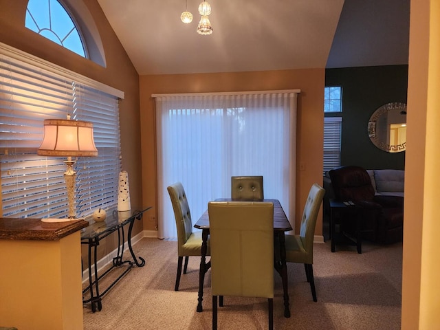 carpeted dining area featuring lofted ceiling