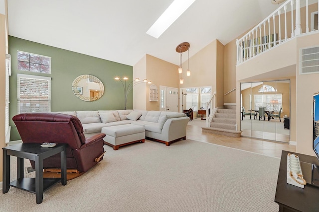 tiled living room featuring a skylight and high vaulted ceiling