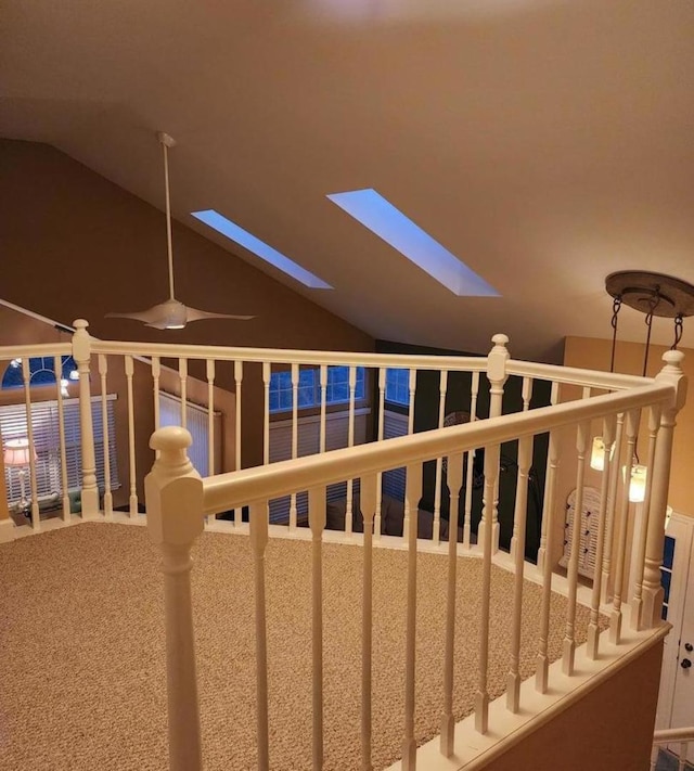 interior space featuring carpet floors and vaulted ceiling with skylight