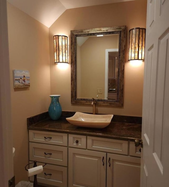 bathroom featuring vanity and lofted ceiling