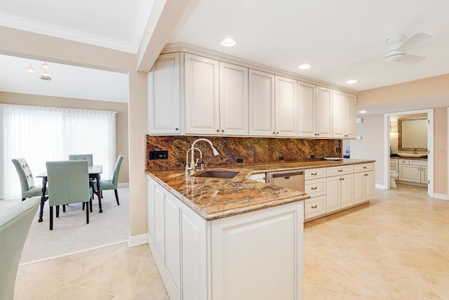 kitchen featuring sink, decorative backsplash, dark stone counters, and kitchen peninsula