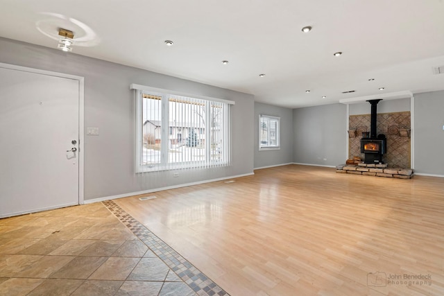 unfurnished living room featuring a wood stove