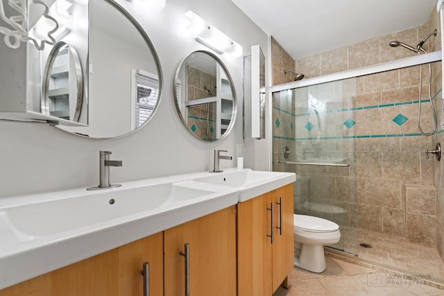 bathroom featuring toilet, tile patterned flooring, an enclosed shower, and vanity