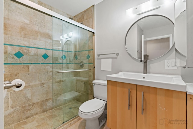 bathroom with toilet, an enclosed shower, and vanity