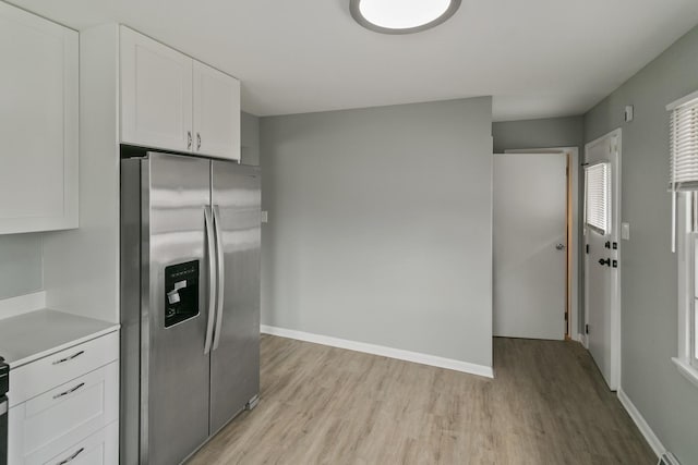 kitchen with white cabinetry, stainless steel refrigerator with ice dispenser, and light hardwood / wood-style flooring