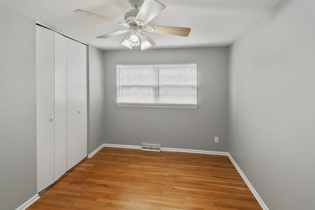 unfurnished bedroom with ceiling fan, a closet, and light hardwood / wood-style flooring