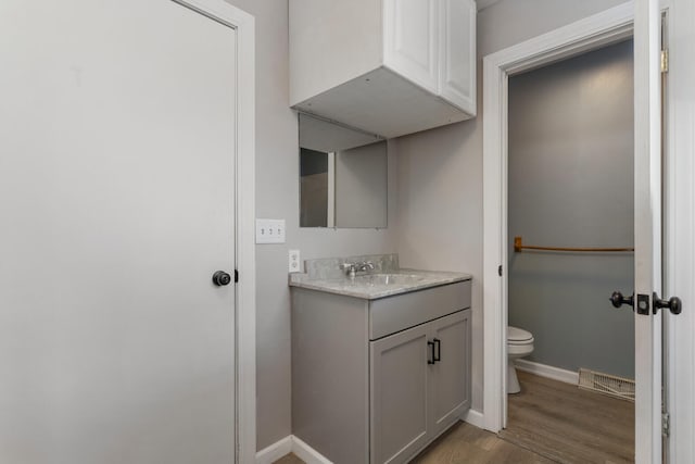 bathroom featuring vanity, hardwood / wood-style floors, and toilet