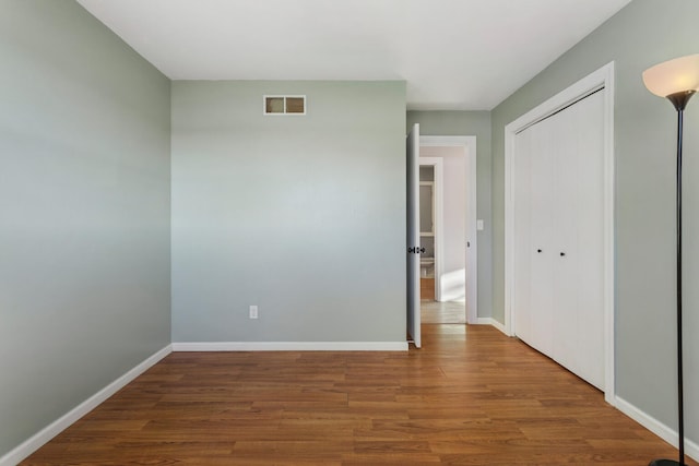 unfurnished bedroom with hardwood / wood-style floors and a closet