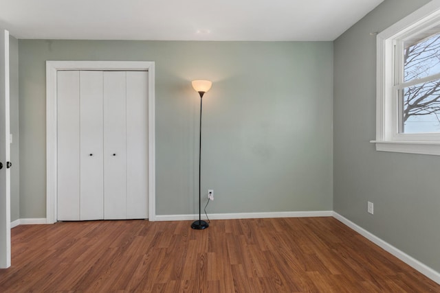 unfurnished bedroom with wood-type flooring and a closet