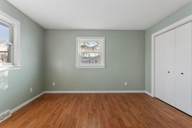 unfurnished bedroom featuring wood-type flooring and a closet