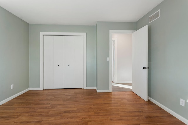 unfurnished bedroom with hardwood / wood-style flooring and a closet