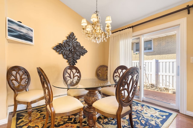 dining space featuring wood-type flooring and a notable chandelier