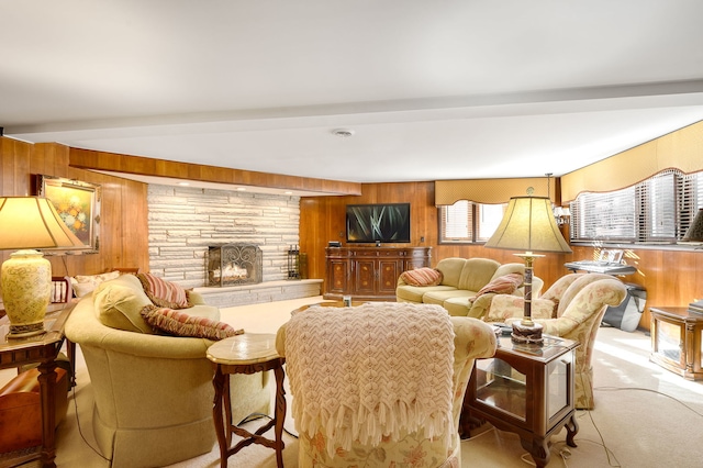 carpeted living room with a fireplace, wooden walls, and beam ceiling