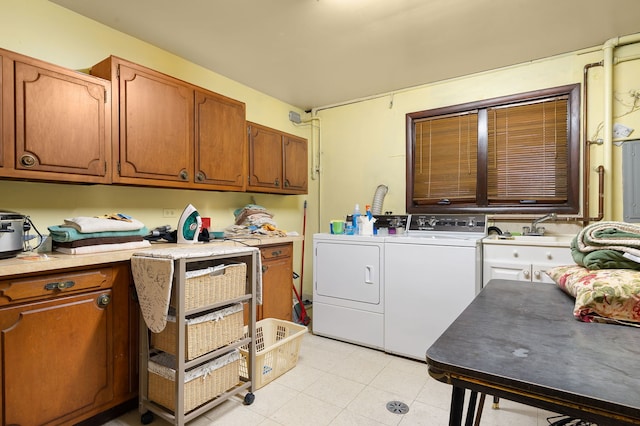 laundry room featuring washer and dryer, cabinets, and sink