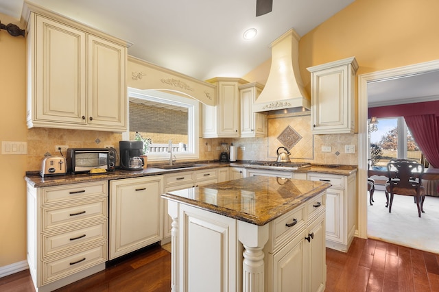 kitchen featuring custom range hood, sink, a center island, dark hardwood / wood-style floors, and dark stone countertops